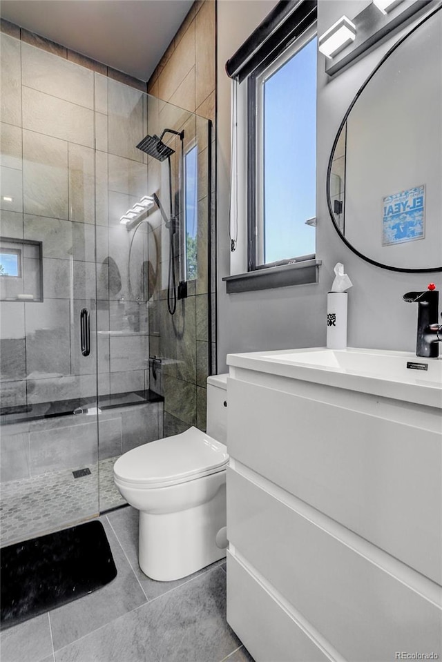 bathroom featuring toilet, a stall shower, tile patterned flooring, and vanity