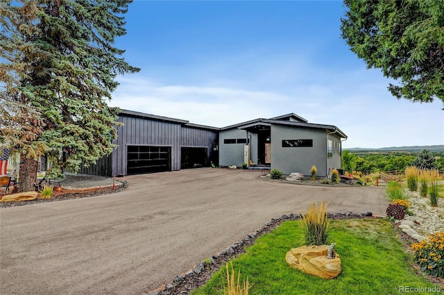 mid-century modern home featuring a garage and driveway