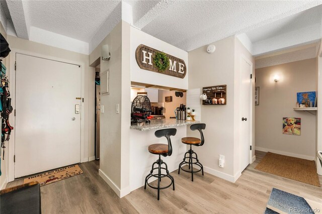 1265 Race St Unit 203, Denver, CO 80206 - hall featuring light wood finished floors, a textured ceiling, and baseboards