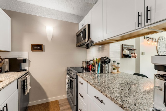 1265 Race St Unit 203, Denver, CO 80206 - kitchen with appliances with stainless steel finishes, baseboards, white cabinets, light stone countertops, and tasteful backsplash