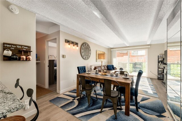 1265 Race St Unit 203, Denver, CO 80206 - dining area featuring a textured ceiling, light wood-type flooring, and baseboards
