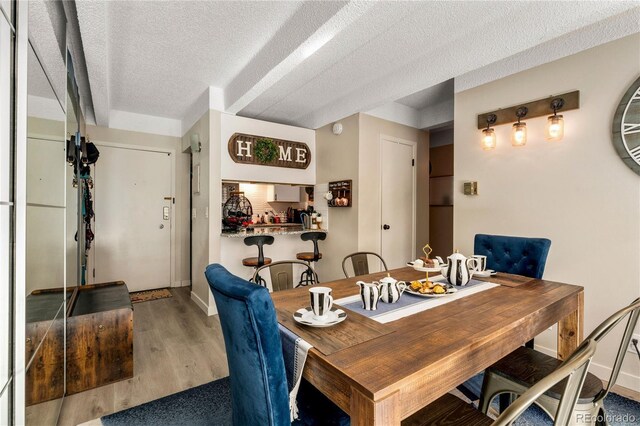 1265 Race St Unit 203, Denver, CO 80206 - dining area featuring wood finished floors, a textured ceiling, and baseboards