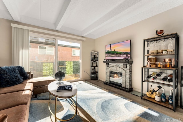 1265 Race St Unit 203, Denver, CO 80206 - living room featuring beam ceiling, a stone fireplace, and wood finished floors