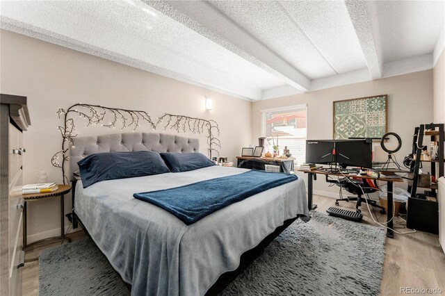 1265 Race St Unit 203, Denver, CO 80206 - bedroom featuring beam ceiling, wood finished floors, a textured ceiling, and an office area