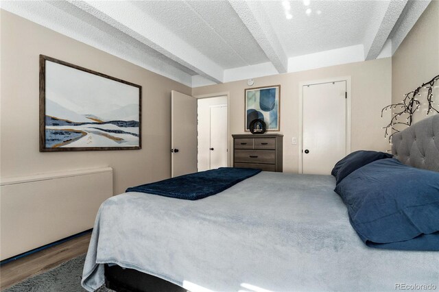 1265 Race St Unit 203, Denver, CO 80206 - bedroom featuring wood finished floors, beamed ceiling, and a textured ceiling