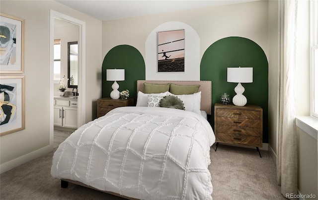 bedroom featuring carpet floors, ensuite bathroom, and multiple windows