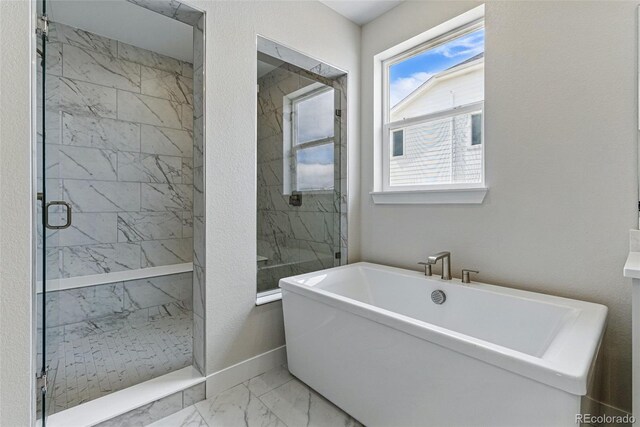 full bathroom featuring a marble finish shower, marble finish floor, baseboards, and a soaking tub