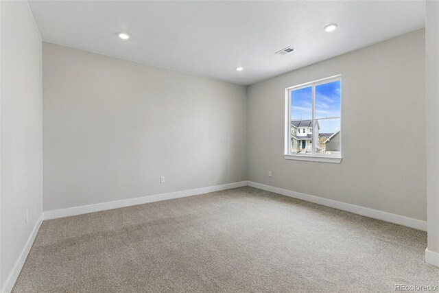 spare room featuring baseboards, recessed lighting, visible vents, and carpet