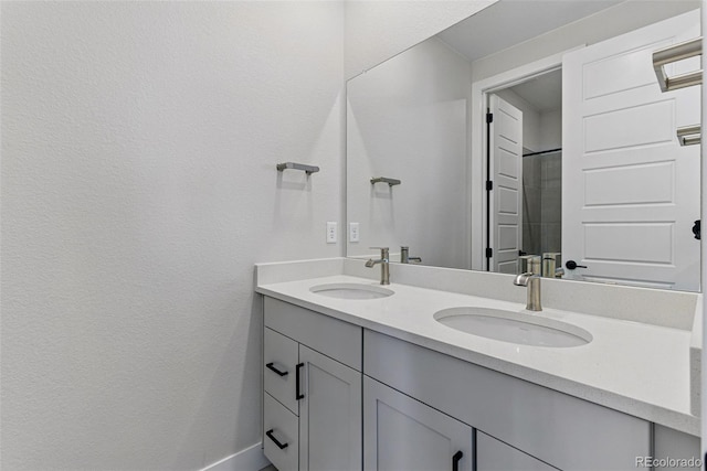 bathroom with a sink, double vanity, and baseboards