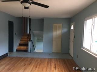 206 Cielo Vista St, Colorado Springs, CO 80911 - unfurnished living room featuring a ceiling fan, healthy amount of natural light, stairway, and light wood finished floors