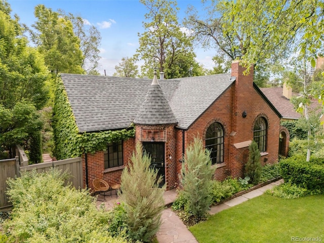 1226 Dexter St, Denver, CO 80220 - tudor home with roof with shingles, brick siding, and a chimney