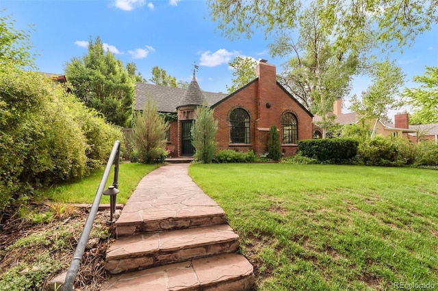 1226 Dexter St, Denver, CO 80220 - tudor house with brick siding, a front yard, and a chimney
