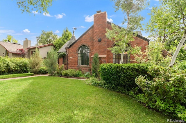 1226 Dexter St, Denver, CO 80220 - view of home's exterior featuring brick siding, a yard, and a chimney