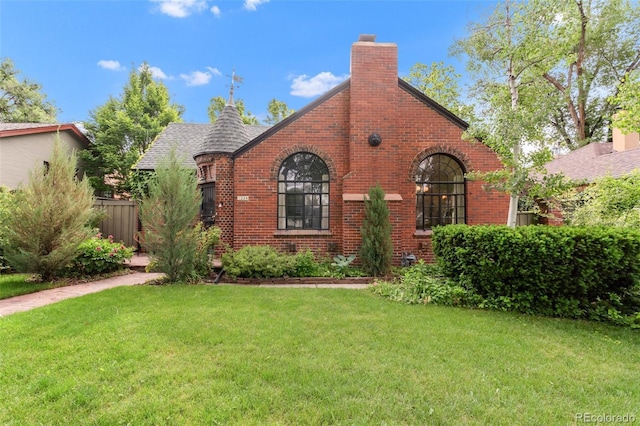 1226 Dexter St, Denver, CO 80220 - tudor-style house featuring brick siding, a chimney, and a shingled roof