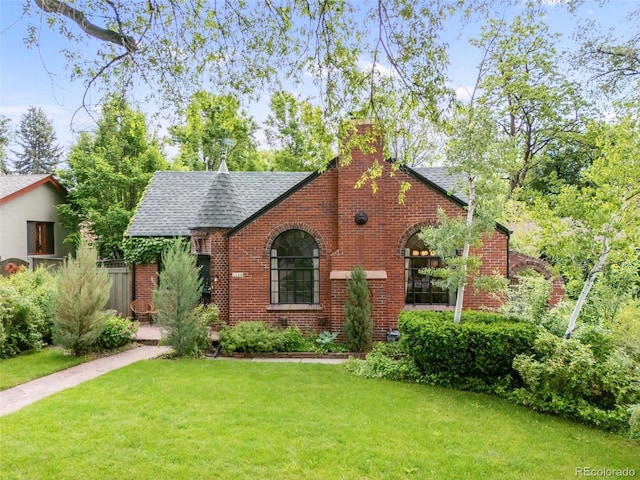 1226 Dexter St, Denver, CO 80220 - tudor house featuring brick siding, a front lawn, and roof with shingles