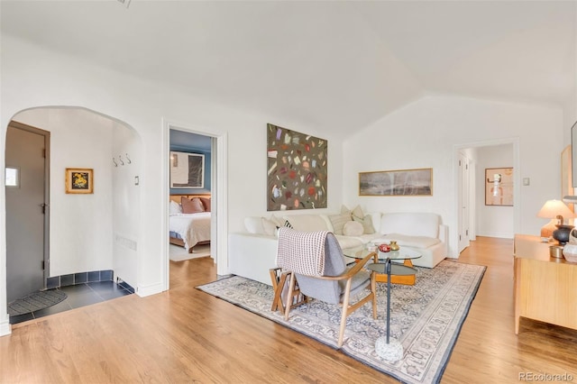 1226 Dexter St, Denver, CO 80220 - living area featuring arched walkways, wood finished floors, lofted ceiling, and baseboards