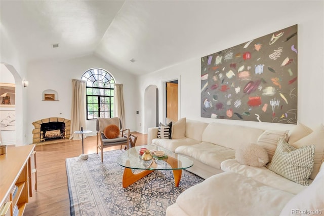 1226 Dexter St, Denver, CO 80220 - living room with arched walkways, vaulted ceiling, wood finished floors, and a fireplace