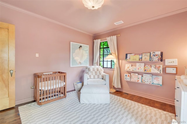1226 Dexter St, Denver, CO 80220 - bedroom with a nursery area, crown molding, wood finished floors, and baseboards