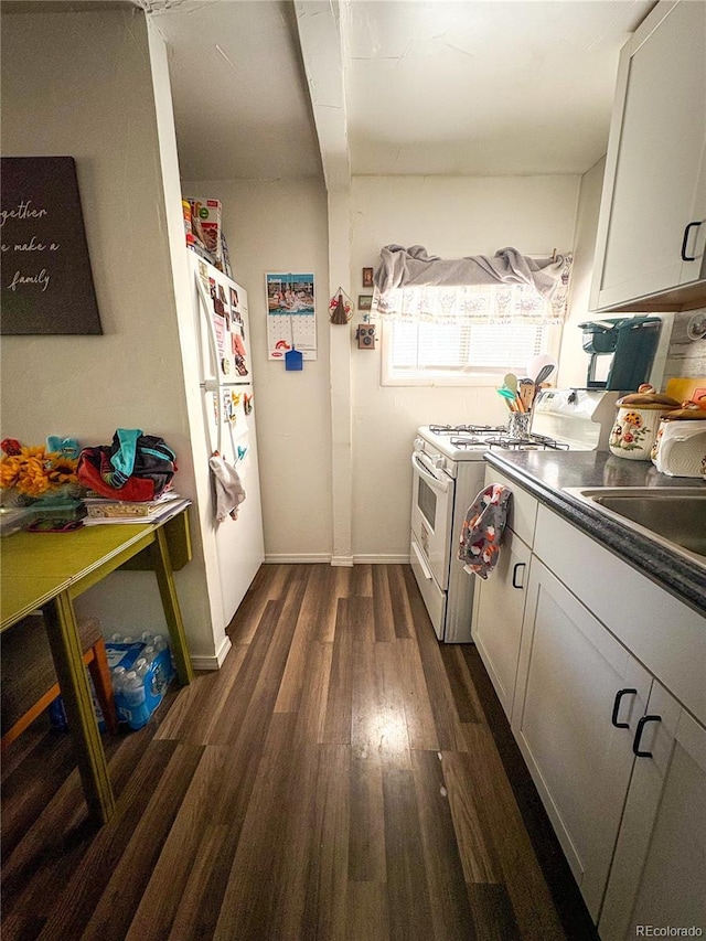 605 E Rio Blanco Ave, Rangely, CO 81648 - kitchen featuring white appliances, dark wood-style floors, dark countertops, and white cabinets