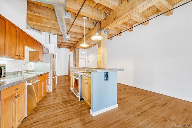 1745 Wazee St Unit 2B, Denver, CO 80202 - kitchen with light wood-style floors, baseboards, light countertops, a sink, and stainless steel appliances