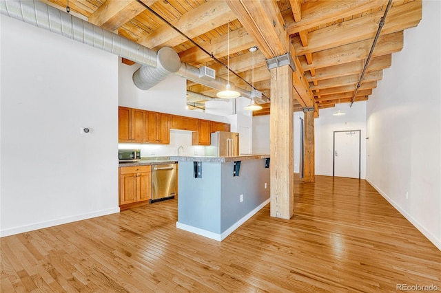 1745 Wazee St Unit 2B, Denver, CO 80202 - kitchen featuring wood ceiling, appliances with stainless steel finishes, light countertops, beamed ceiling, and light wood-style floors