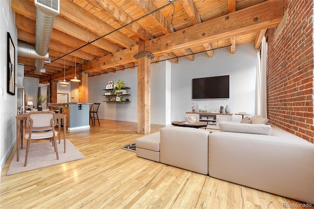 1745 Wazee St Unit 2B, Denver, CO 80202 - living area featuring visible vents, wood finished floors, brick wall, beam ceiling, and wood ceiling