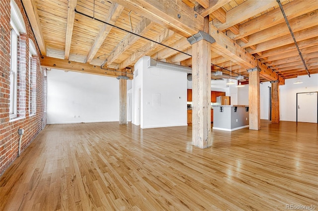 1745 Wazee St Unit 2B, Denver, CO 80202 - unfurnished living room with baseboards, wood finished floors, brick wall, and wooden ceiling