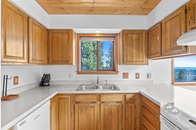 kitchen featuring light countertops, a sink, white appliances, and brown cabinetry