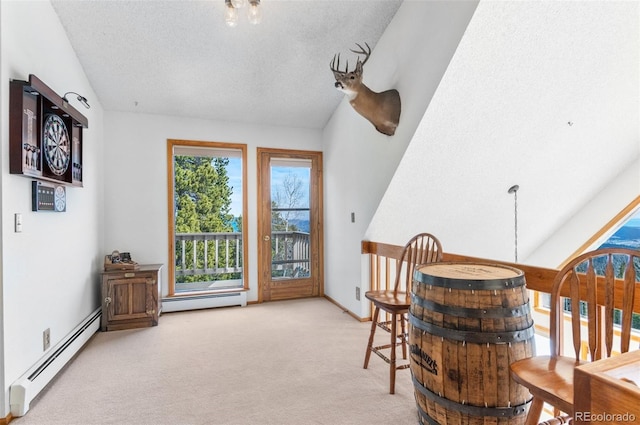 dining space with baseboard heating, a textured ceiling, carpet flooring, and baseboards
