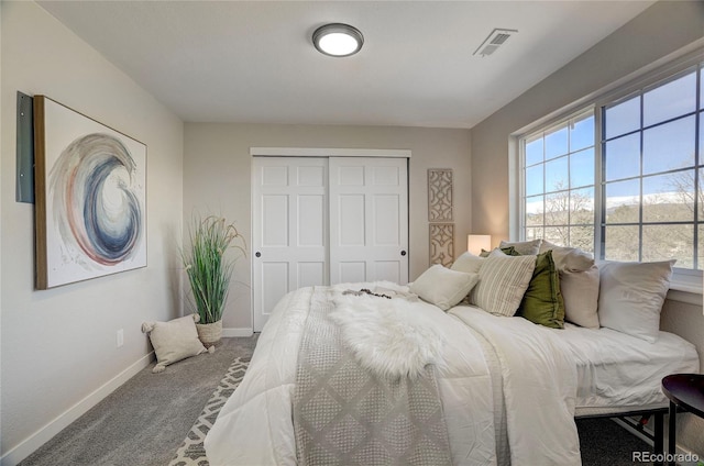 carpeted bedroom featuring a closet, visible vents, and baseboards