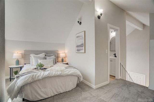 bedroom featuring carpet floors, baseboards, ensuite bathroom, and lofted ceiling