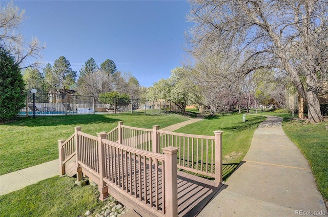 view of community with fence and a lawn