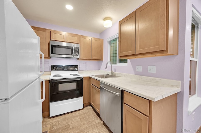 922 S Dearborn Way Unit 8, Aurora, CO 80012 - kitchen with appliances with stainless steel finishes, light countertops, a sink, and light wood-type flooring