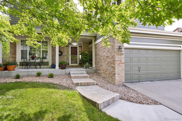 view of front of home featuring covered porch, brick siding, driveway, and a front lawn