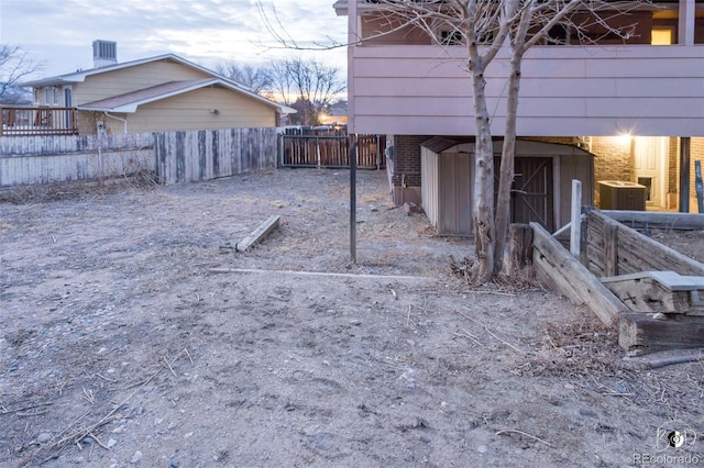 yard at dusk with a storage unit and central AC unit