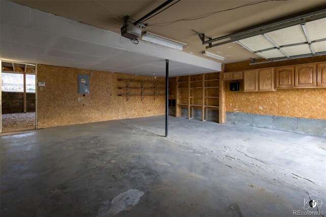 garage with electric panel and a garage door opener