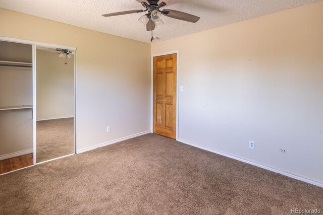 unfurnished bedroom with carpet flooring, a textured ceiling, a closet, and ceiling fan