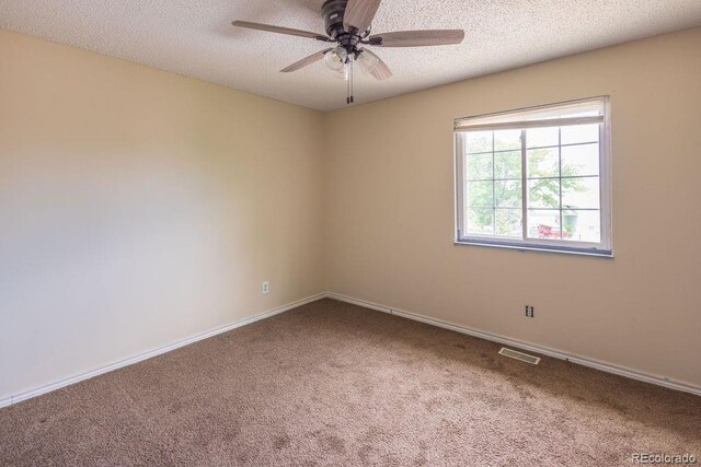 empty room with ceiling fan, a textured ceiling, and carpet floors