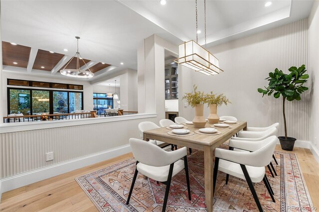 dining space with light hardwood / wood-style flooring and a notable chandelier