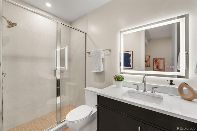 bathroom with vanity, a shower with shower door, and toilet