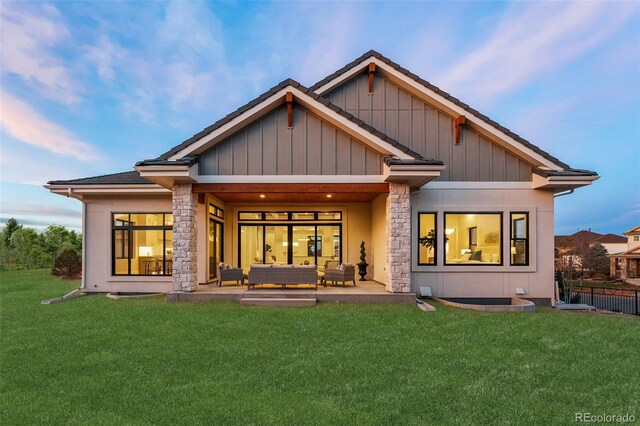 back of property with an outdoor living space, a patio area, and a yard