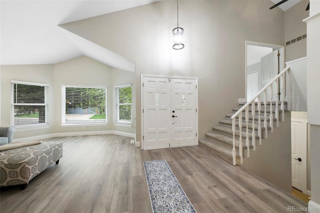 11245 San Joaquin Rdg, Littleton, CO 80127 - entrance foyer with high vaulted ceiling, stairs, wood finished floors, and baseboards