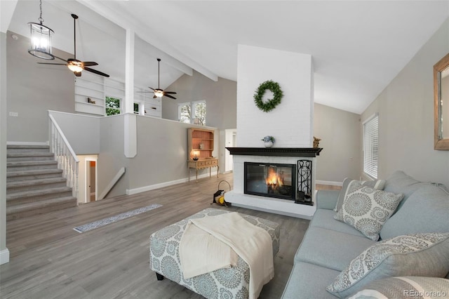 11245 San Joaquin Rdg, Littleton, CO 80127 - living area featuring wood finished floors, ceiling fan, a brick fireplace, baseboards, and beamed ceiling