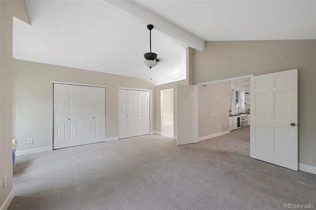 11245 San Joaquin Rdg, Littleton, CO 80127 - unfurnished bedroom featuring carpet flooring, two closets, beamed ceiling, baseboards, and high vaulted ceiling