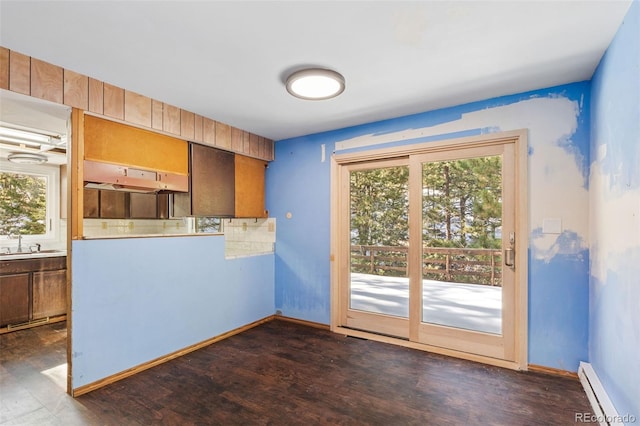 kitchen featuring dark hardwood / wood-style flooring, baseboard heating, plenty of natural light, and sink