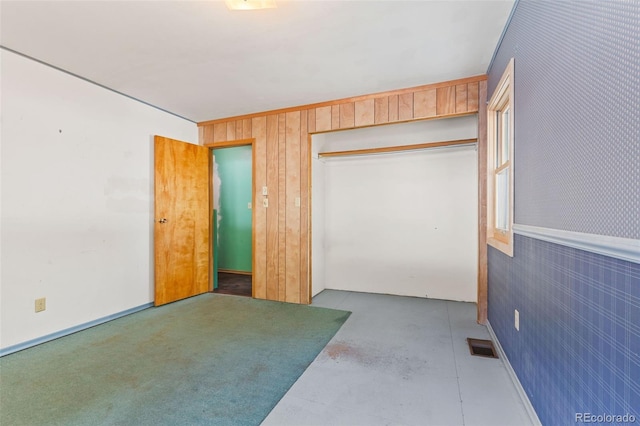 interior space with a closet and wood walls