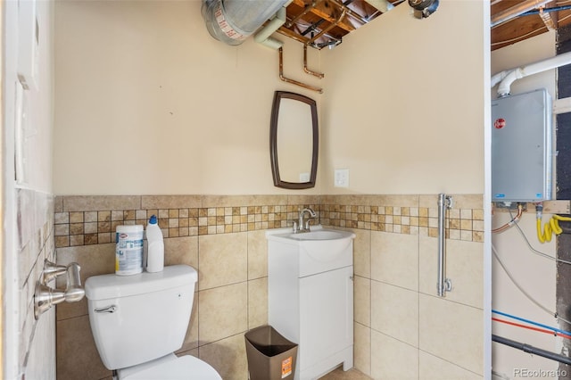 bathroom with vanity, tankless water heater, and tile walls