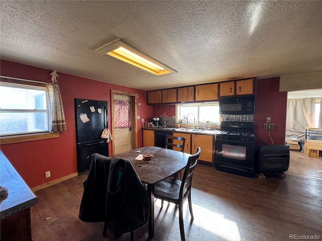 dining space featuring sink, dark hardwood / wood-style floors, and a textured ceiling