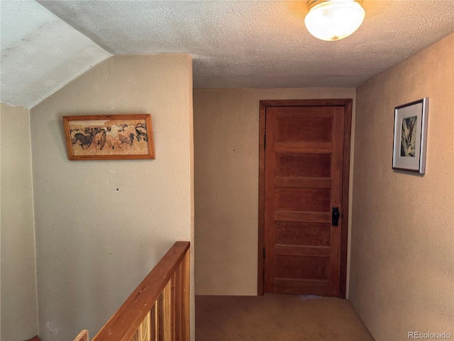 hallway featuring lofted ceiling and a textured ceiling