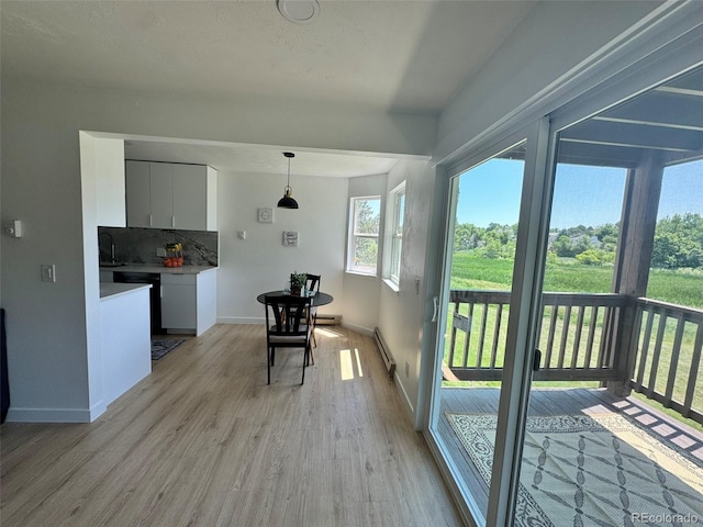 17361 E Mansfield Ave Unit 521R, Aurora, CO 80013 - dining room featuring a baseboard heating unit and light wood-style floors